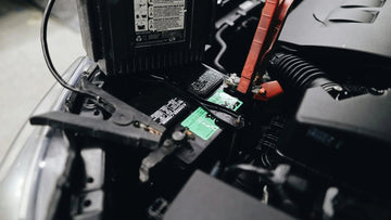 Close-up of car battery with jumper cables attached, automotive maintenance concept
